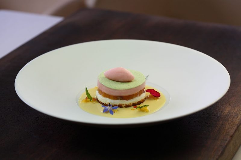 Cheesecake con pesche al prosecco, salsa all’acqua di rose e parfait al prezzemolo