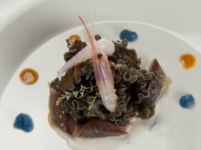 Lasagne ricce al sugo nero di seppia con gambero gobbetto, cicala di mare e sugherello