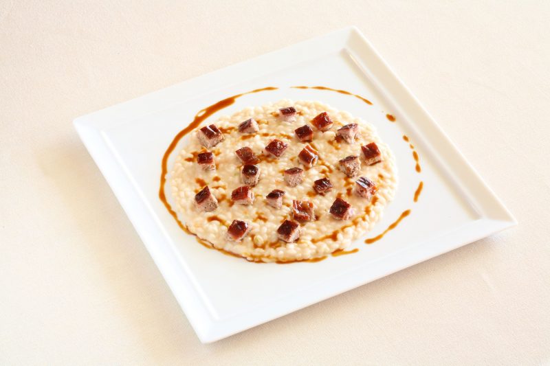 Risotto mantecato al leggero profumo di cannella
con ragù di maialino allo spiedo