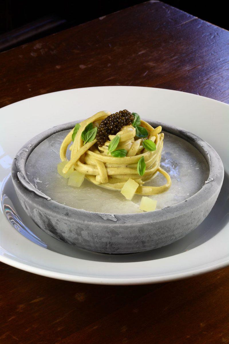 Tagliolini al pesto di pistacchio, mela e caviale su ghiaccio affumicato